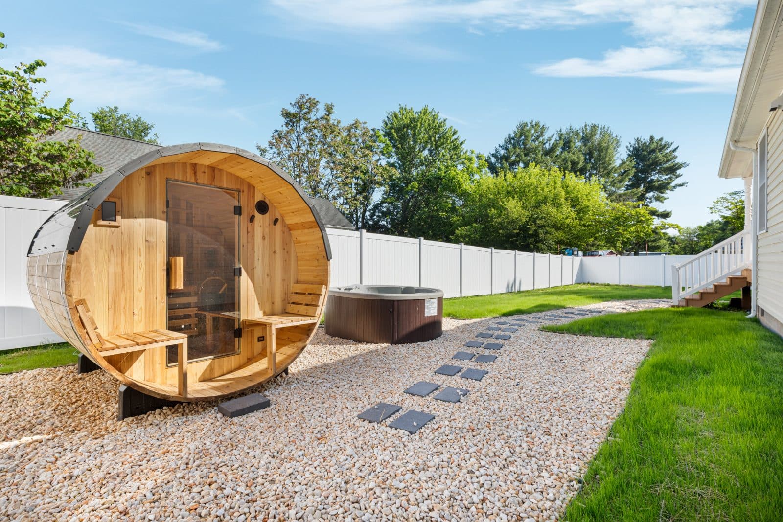 Private hot tub and barrel sauna in the fenced backyard at Heart of Luray