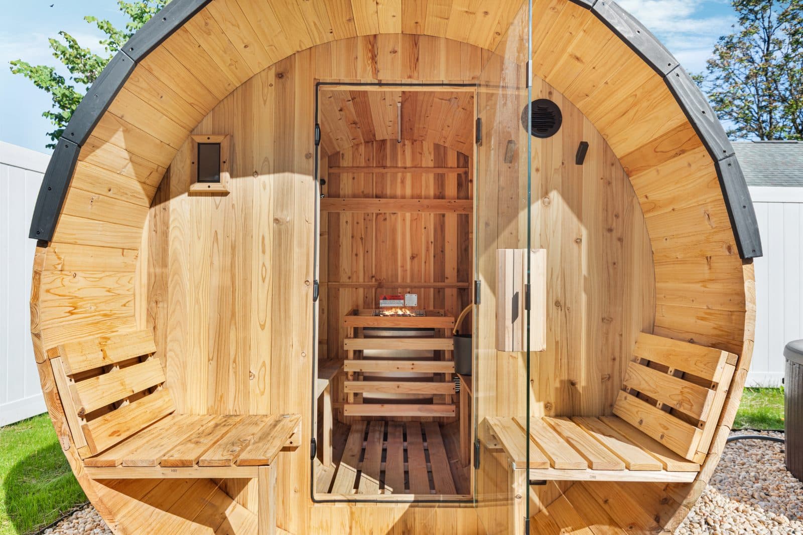 The private cedar barrel sauna in the fenced backyard at Heart of Luray